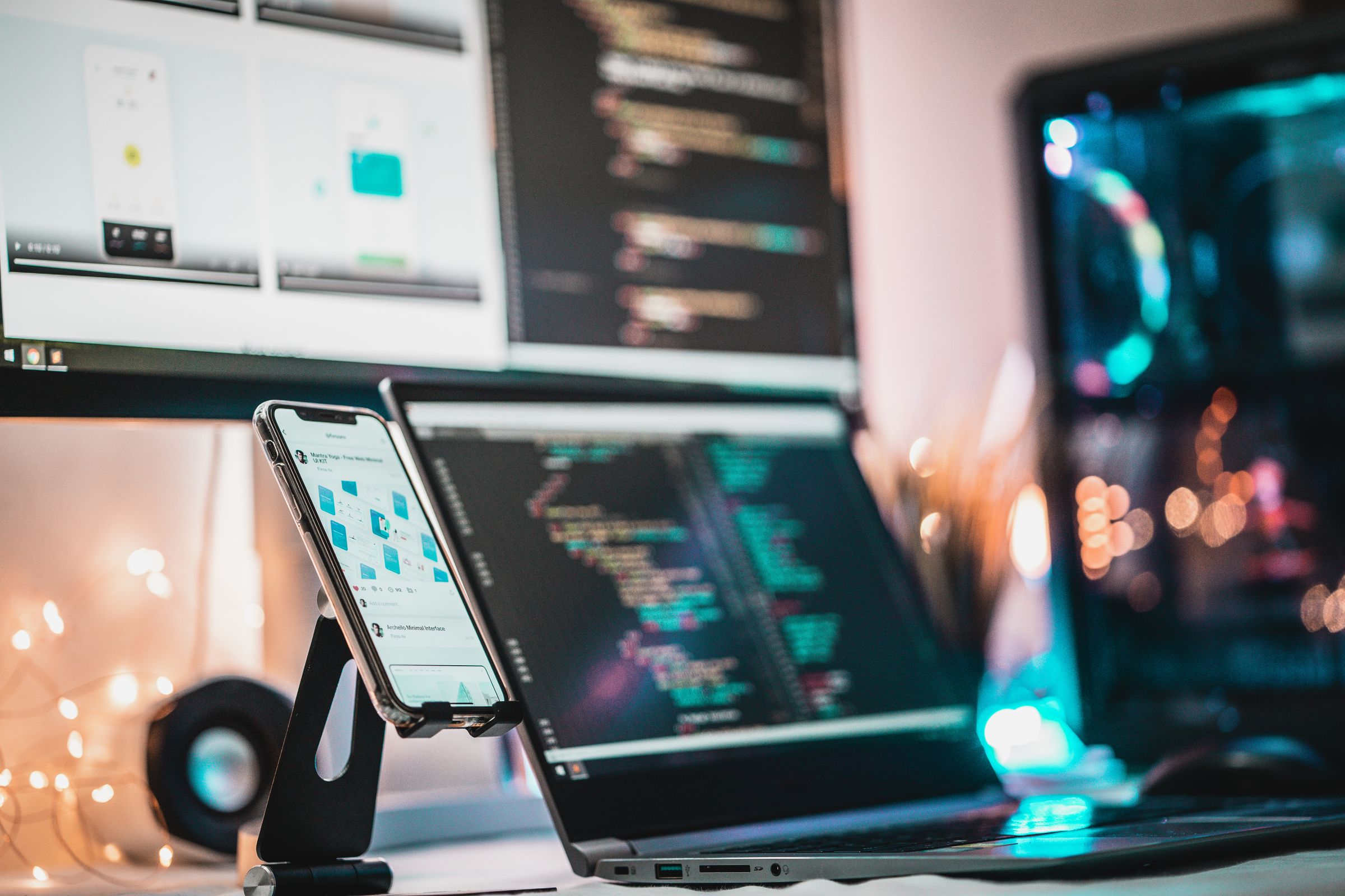Phone beside a code editor in a developer setup